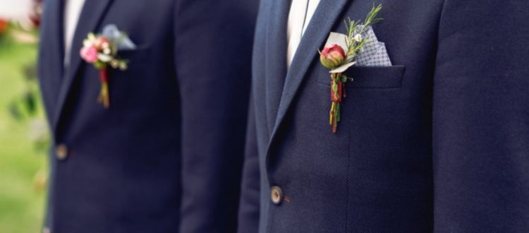 Trajes masculinos de cerimônia com boutonnieres florais presos às lapelas dos paletós.